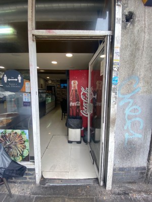 Glass door with white frame. Push from left to open. Main area straight ahead.