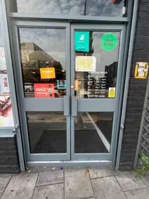 Glass double push doors with grey handles in the middle.