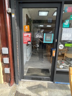 Glass door with grey border. Push to enter on right side.
