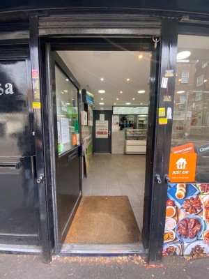 Glass door with black frame. Push from right to open. Main area straight ahead.