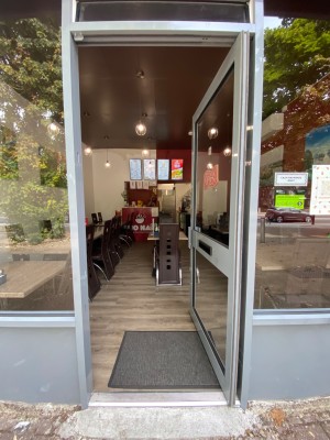 Push glass door with handle on the left.