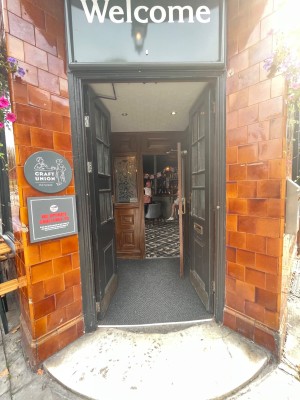 Black wood-panelled glass double doors. Push from centre to open.