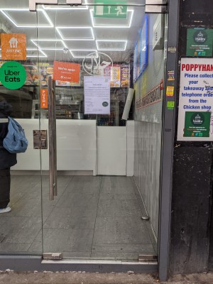 Glass door with metal handle on left. Push to open.