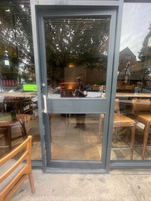 Push glass door with handle on the left.