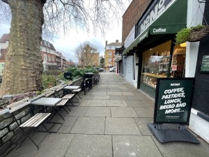 From pavement facing straight. Outdoor seating on left. Venue entrance on right.