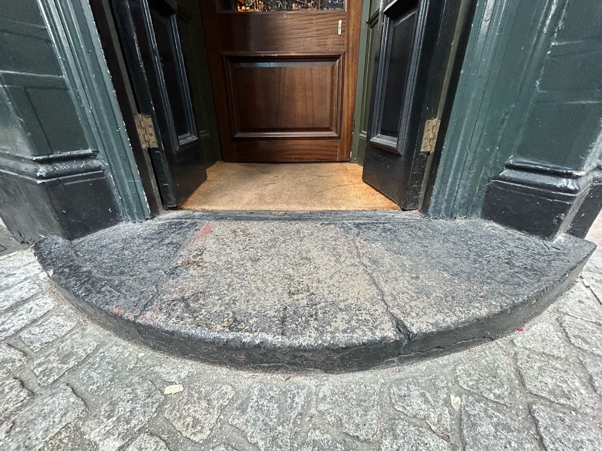 Step up to preceding doors. Doormat beyond.
