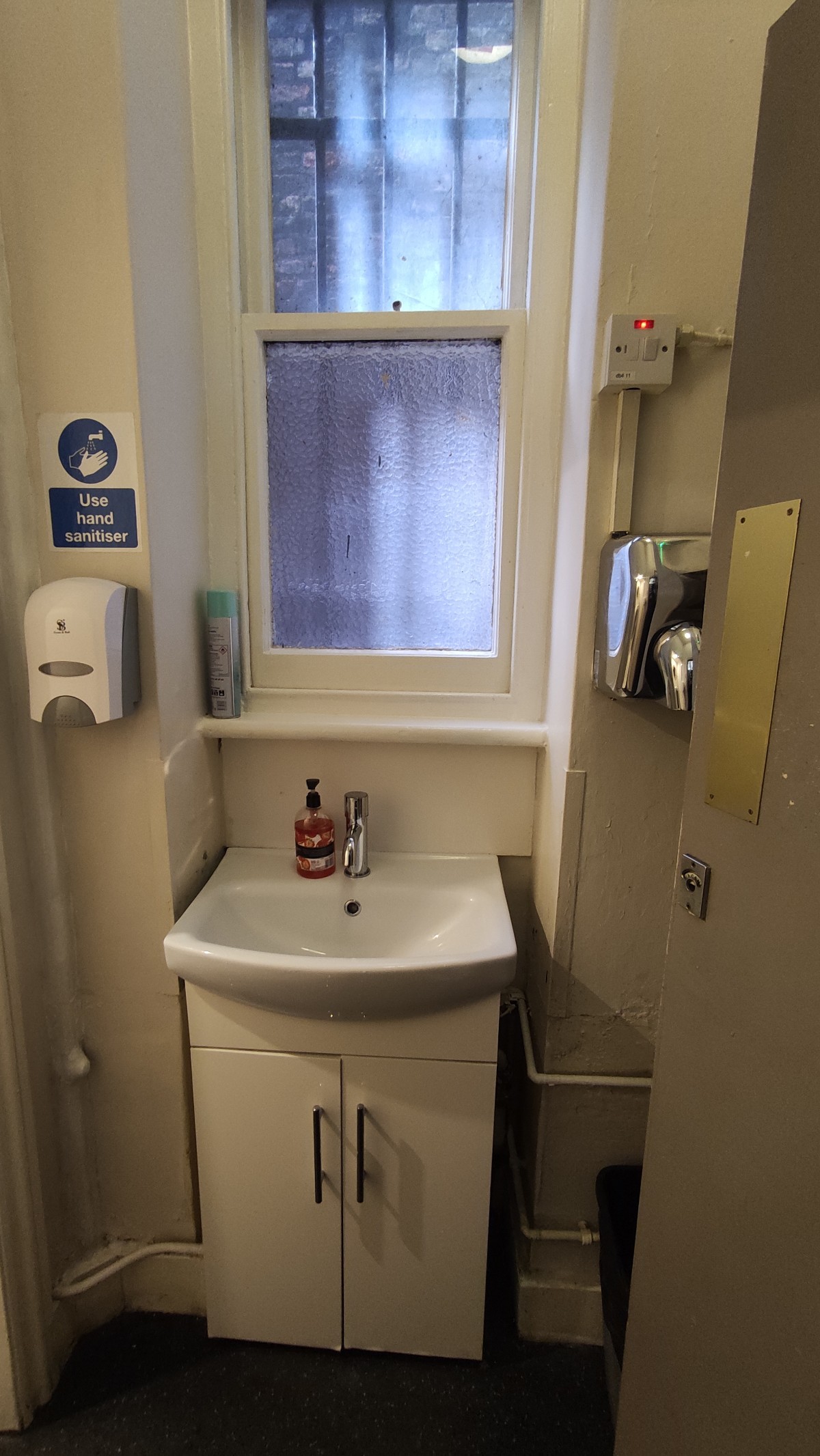 From door facing straight. Sink at the back wall. Open bin behind door to right.