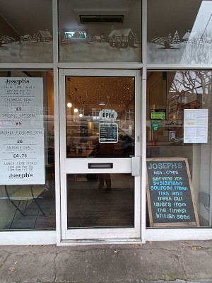 Glass door with white frame. Push silver, metal handle on right to open.