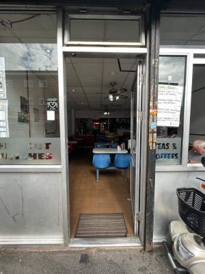 Grey metal framed glass push door with handle on left.