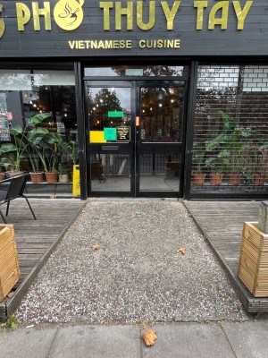 Ramp to double black and glass doors with handle in middle.