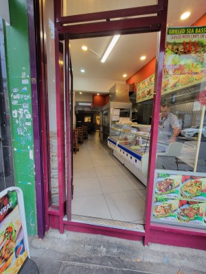 Glass door with red metal frame, push from right to open.