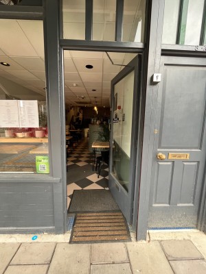 Grey framed glass door. Push handle on left to open.