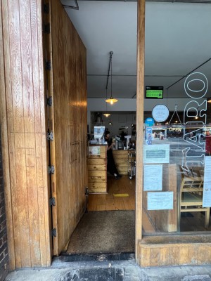 Push wooden door with handle on left.