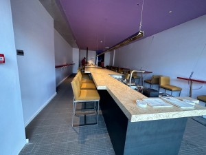 From entrance looking straight ahead with countertop on the center right. Path on both sides.  High table on the left.