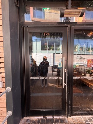Glass door with black frame ahead. Pull metal handle at center right to open door.