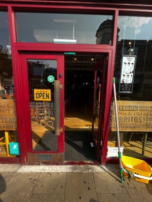 Glass double doors with red frame. Push from middle to open. Small bump at foot of door.