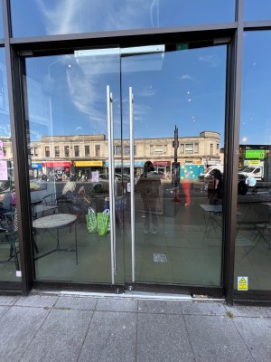 Glass doors with black frame. Push metal handles from centre to open.