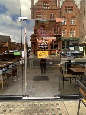 Glass door with handle on right. Push to open.