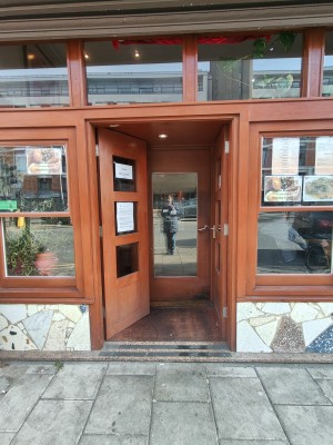 Brown framed glass preceding doors. Push silver handle on right to open.