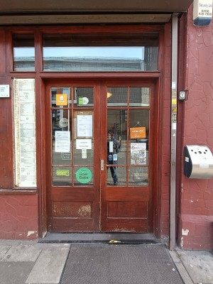 Glass doors with brown, wooden frame. Push from middle to open.
