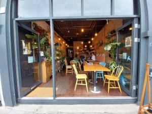 Entrance from street. Two doorways, narrow to left and broad to right. Seating just inside right doorway.