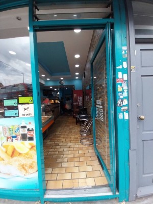 Glass door with blue frame. Push blue handle from left to open.