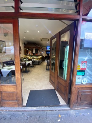 Glass door with wooden frame. Push from left to open.