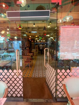Glass door with pink metal handles in middle. Push to open.