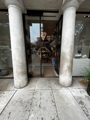 Glass double doors with black frame. Push from middle to open. Stairs to upstairs on right and left ahead. Lift to right of entrance.
