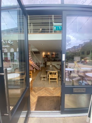 Double glass doors with black frames. Pull brown wooden handle from middle to open.