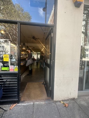 Single glass door with handle on the left. Push.