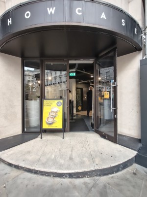 Facing brown-framed double glass doors. Pull silver metal vertical handles from centre to open.