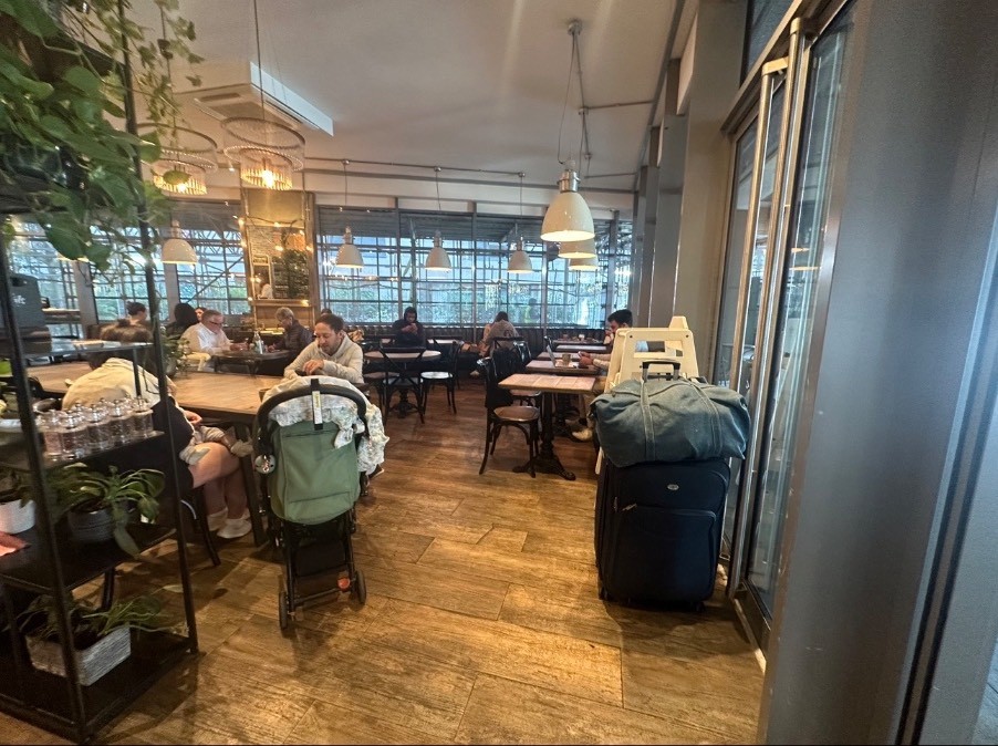 From entrance looking to the right. Path straight ahead to seating. Division shelve on the left followed by table.