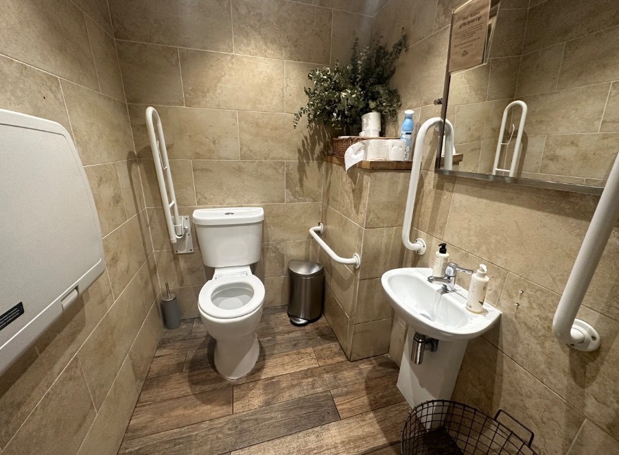 From entrance looking straight ahead to wc. Sink on the right. Baby changing facility on the left.