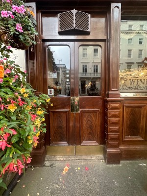 Wood doors with glass panels ahead. Push doors to open via golden pads in center.
