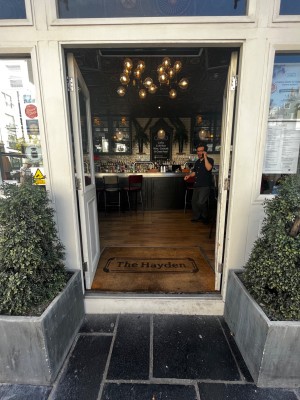 Glass door with white frame. One step up through door. Push from middle to open.