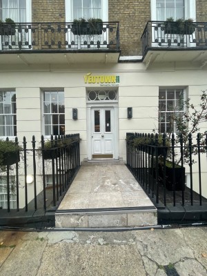 One large step leading up to raised platform before door. Black fencing on either side.