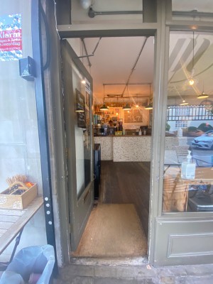 Glass door with light brown frame. Push from right to open.