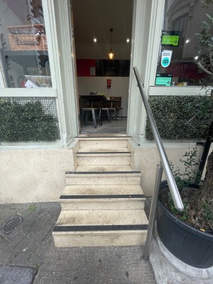 Five large steps leading up to door. Handrail to the right.