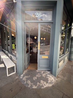 Glass doors with blue frame ahead. Push via pads in center to open.