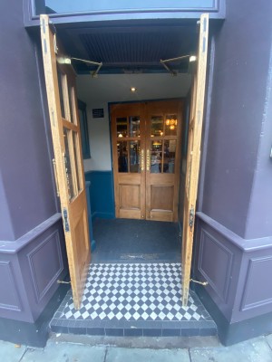 Wooden and glass double doors. Pull open from middle. Second set of doors straight ahead. Wooden and glass double doors, that pull open from middle.