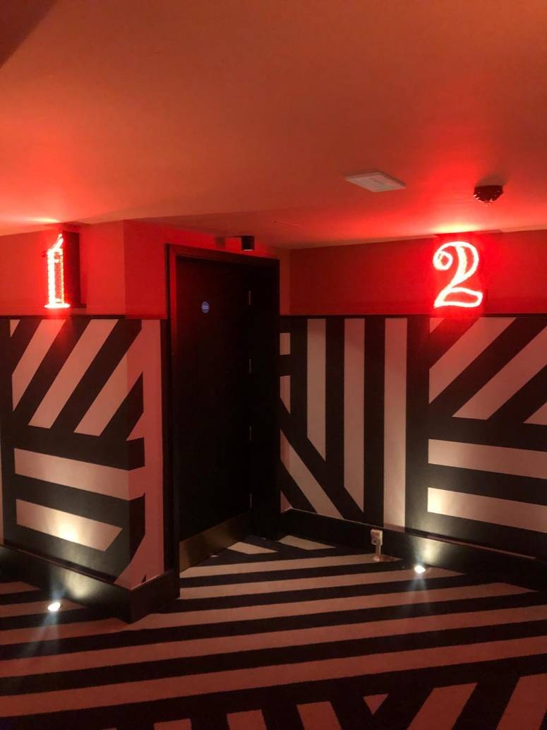 Hallway to the cinema screens. Led signs to label each screen.