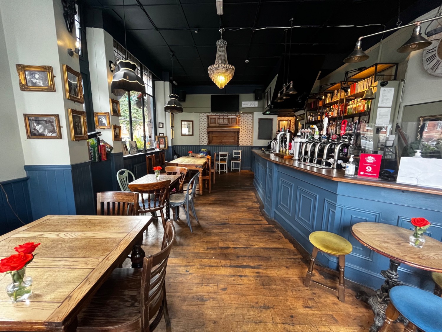 Facing left before bar. Tables with chairs along left side. Bar counter along right. Central path extends back.