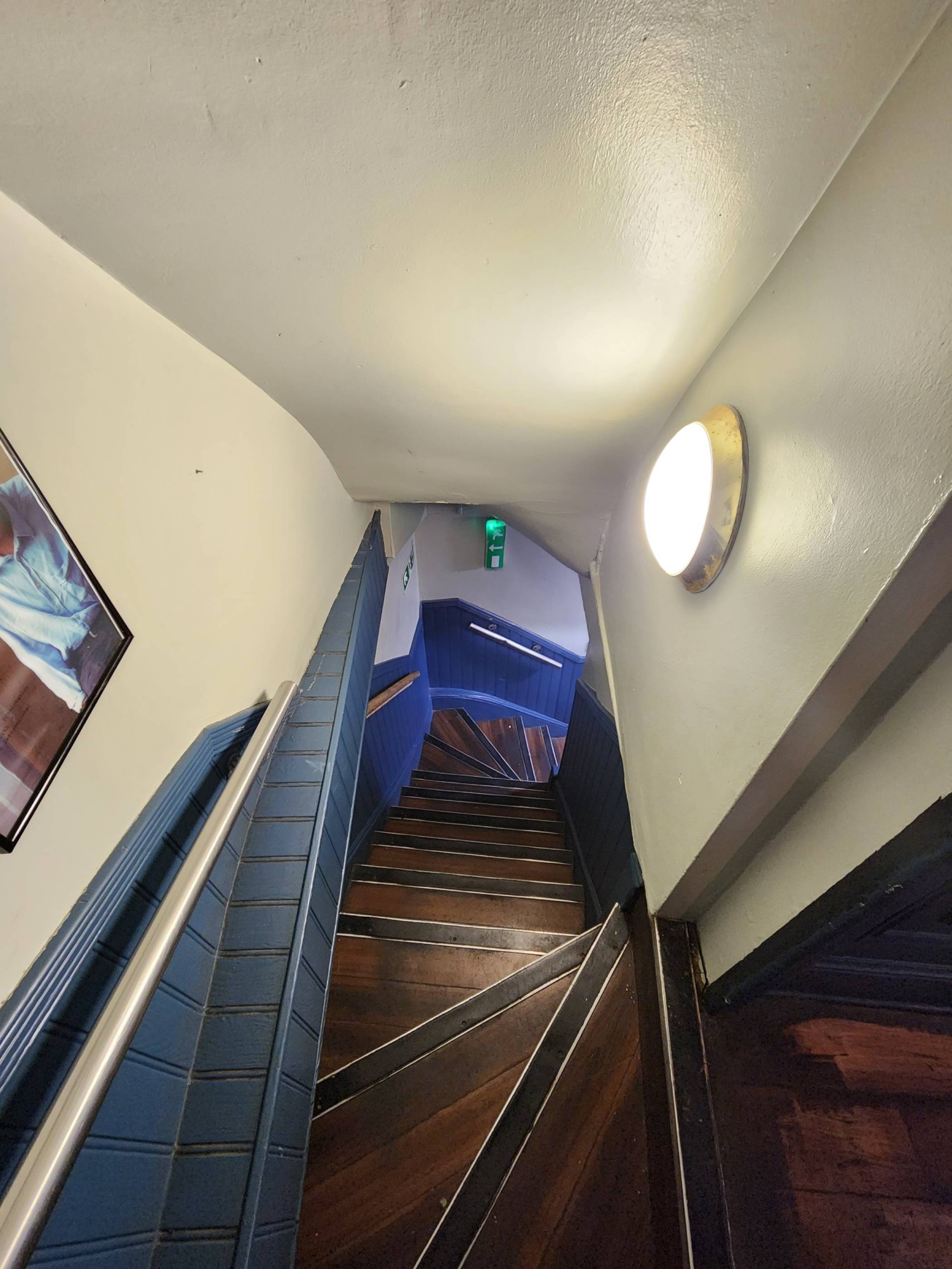 From archway looking right. Staircase leading down with handrail on left.