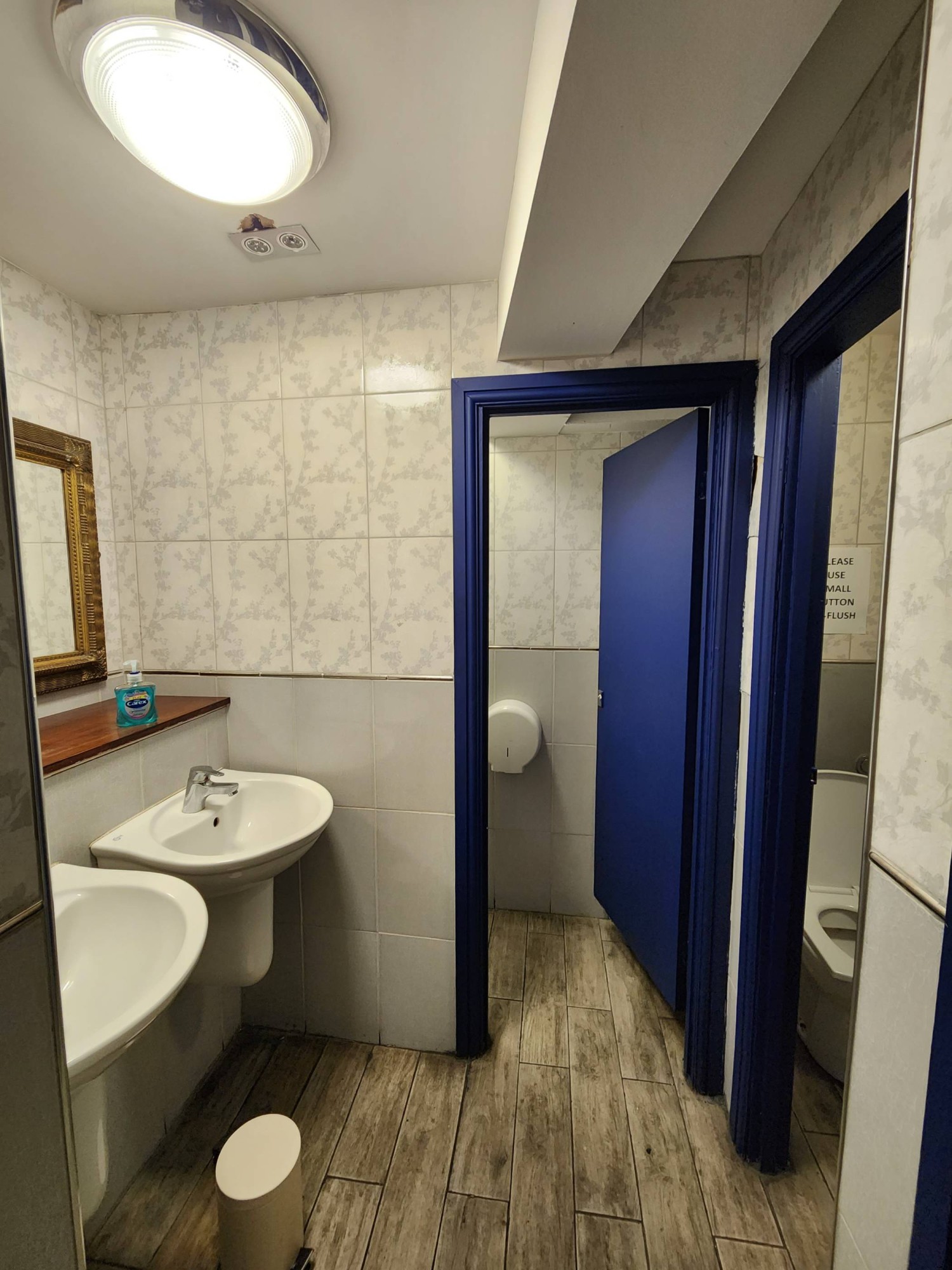 From bathroom door, looking to the right. Sinks to left. Bathroom cubicle door straight ahead. Push to open from left.