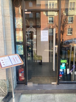 Glass door ahead with silver grab rail on right. Push from right to open.