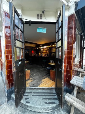 Black double doors. Pull from middle to open. One step up to door. Small bump at foot of door.