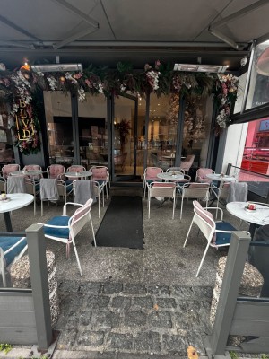 Path to door through outdoor seating. Door ahead.