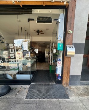 Metal ramp followed by single glass door with handle on the left. Push.