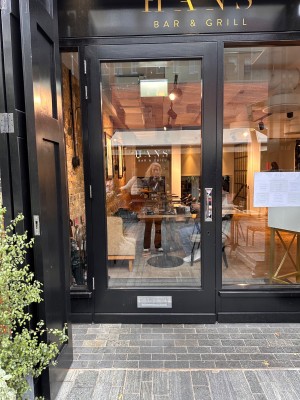 Glass door with black frame. Pull handle from right to open.